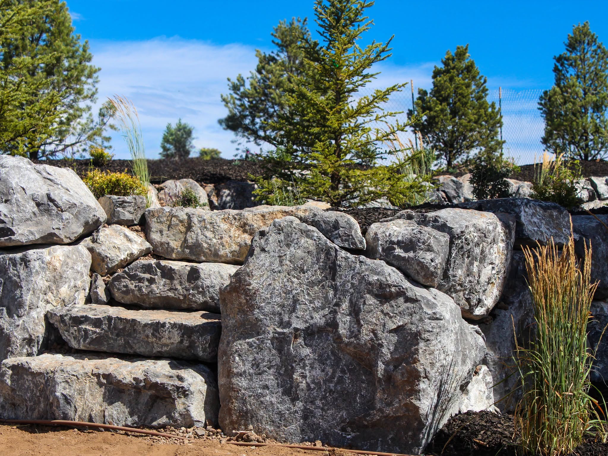 Natural boulder retaining wall built by Pine Canyon