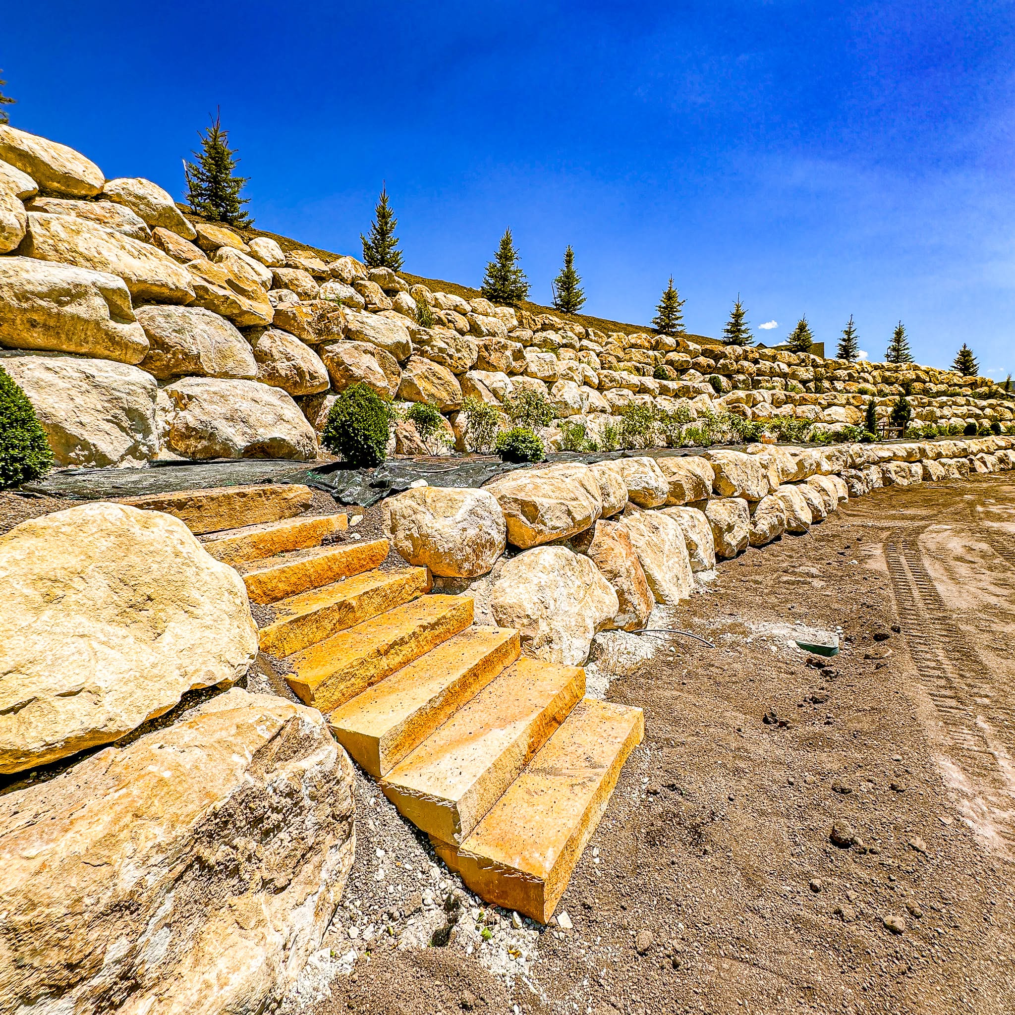 Large Pine Canyon boulder retaining walls with integrated stone stairs